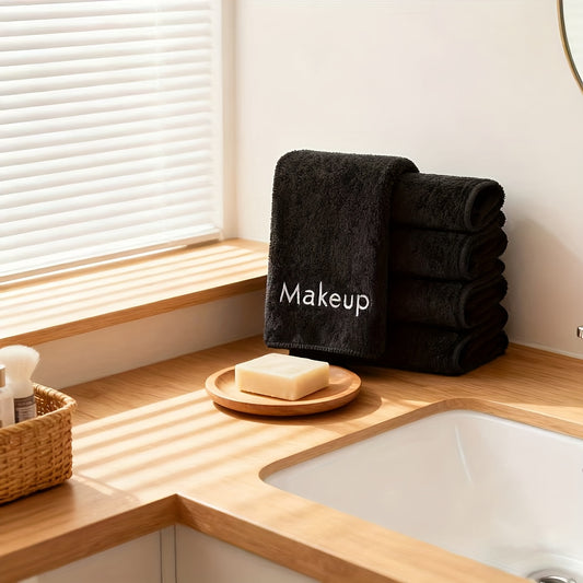Black towel labeled 'Makeup' on a wooden bathroom counter with soap and a basket.