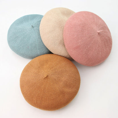 Four colorful berets (blue, beige, pink, and brown) on a white background