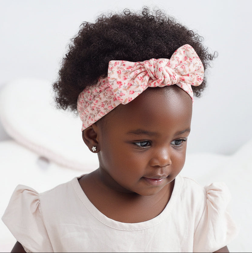 Child wearing a floral headband with a white background