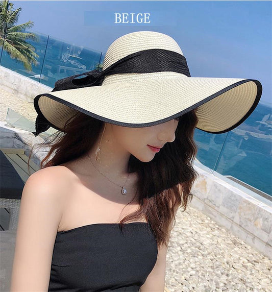 Woman wearing foldable floppy straw paper sun hat at the beach in summer